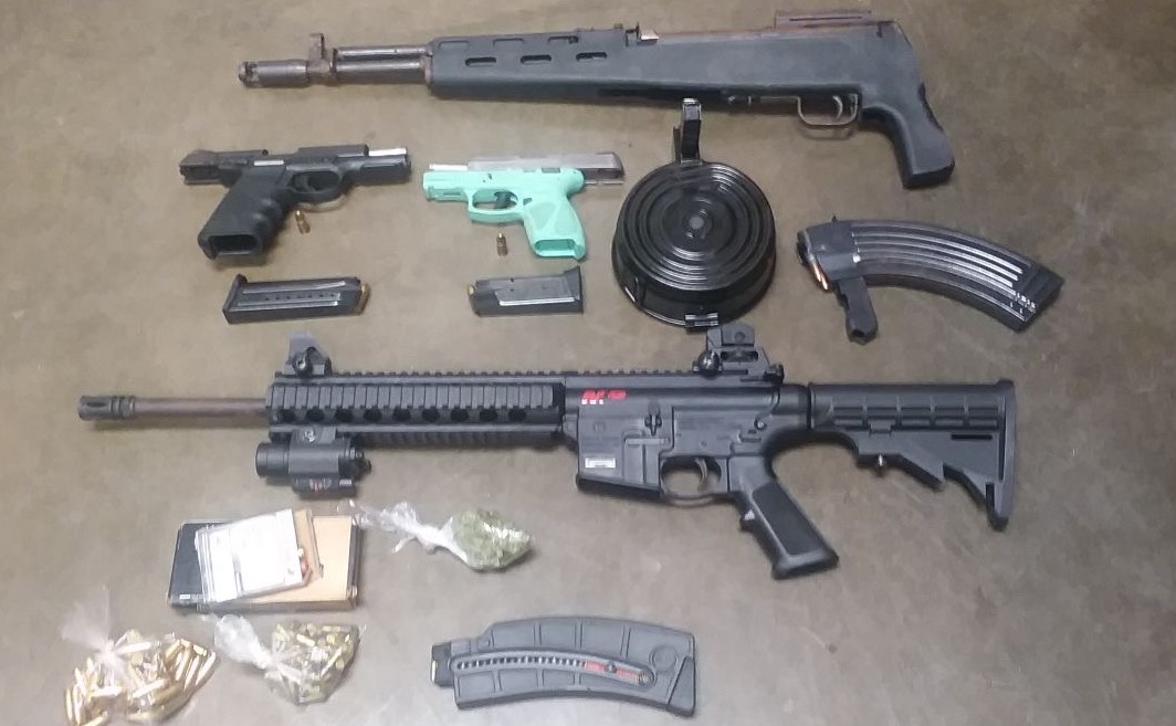A man wanted by U.S. Marshals allegedly had these firearms and marijuana in his home when he was arrested.