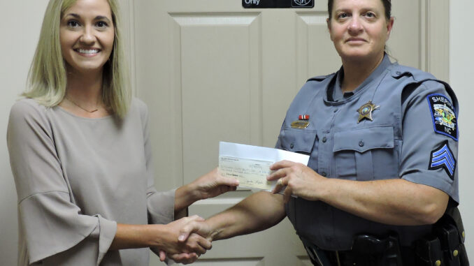 Amanda Formyduval presents Sgt. Pam Bryan with a check from the Good Shepherd Fund.