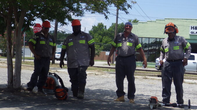 Despite 100-degree heat indices, these workers with the city of Whiteville were mowing and trimming along West Main Street Friday.