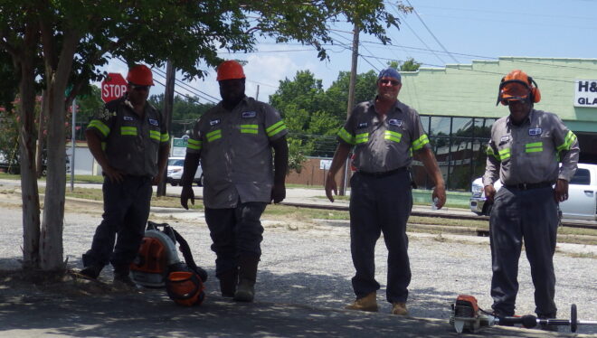 Despite 100-degree heat indices, these workers with the city of Whiteville were mowing and trimming along West Main Street Friday.