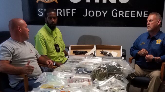 Sheriff Jody Greene, Chief of Detectives Jeremy Barber and Barrett Thompson of the Vice Narcotics unit with some of the drugs and other contraband seized during Friday's raids.