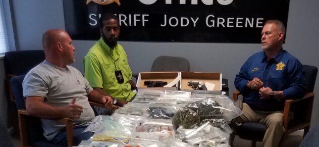 Sheriff Jody Greene, Chief of Detectives Jeremy Barber and Barrett Thompson of the Vice Narcotics unit with some of the drugs and other contraband seized during Friday's raids.