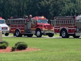 Fire trucks line up at People's Funeral Home after escorting Billy Six Monday.