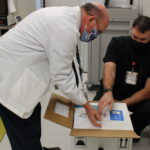 UNC Health Southeastern Pharmacy Director Eric Locklear and Pharmacist Brett Duncan unpack the first COVID-19 vaccines at Southeastern. (Submitted)