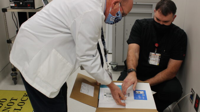 UNC Health Southeastern Pharmacy Director Eric Locklear and Pharmacist Brett Duncan unpack the first COVID-19 vaccines at Southeastern. (Submitted)