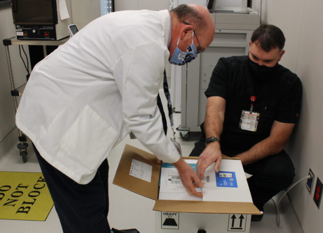 UNC Health Southeastern Pharmacy Director Eric Locklear and Pharmacist Brett Duncan unpack the first COVID-19 vaccines at Southeastern. (Submitted)