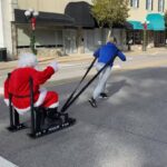 A woman pulling a sleigh where Santa Claus seats