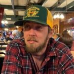 A man wearing a cap and a plaid shirt