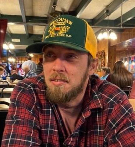 A man wearing a cap and a plaid shirt
