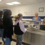 Clariece Hammonds and Selina Gore greet some of the summer lunch guests.