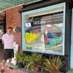 Christopher Gower in front of his art gallery and tattoo parlor.