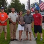Mitch Simmons, Gray Rogers, Charlotte and Mike Hollingsworth, and Mike Fishburn take a moment while erecting the dozens of flags along Flemington Drive Thursday.