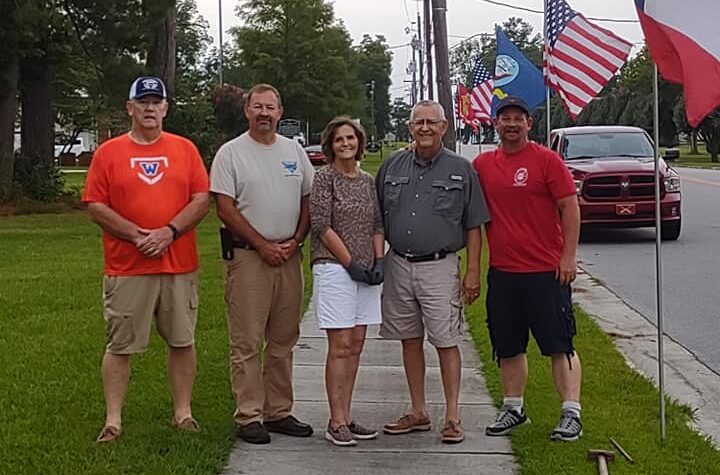 Mitch Simmons, Gray Rogers, Charlotte and Mike Hollingsworth, and Mike Fishburn take a moment while erecting the dozens of flags along Flemington Drive Thursday.