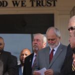 Surrounded by local elected officials and representatives form area towns, Brenden Jones addresses the crowd Friday morning. (Sammy Hinson photo)