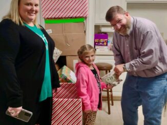 Dave Heller accepts Paisley Stevens' donation of $85 for the CBA Toy Store. Paisley's mother, Ash-Leigh Hewitt Stevens, thought Paisley was saving up for an iPhone.