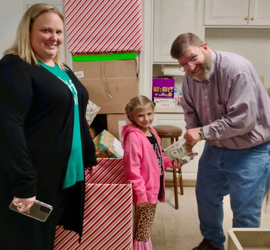 Dave Heller accepts Paisley Stevens' donation of $85 for the CBA Toy Store. Paisley's mother, Ash-Leigh Hewitt Stevens, thought Paisley was saving up for an iPhone.