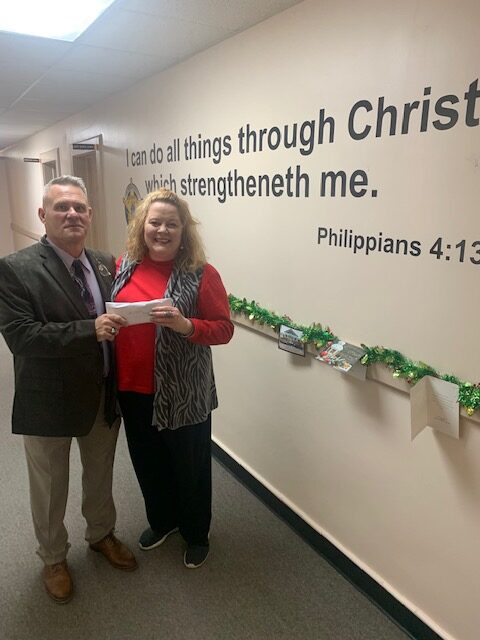 Sheriff Jody Greene presents Wallace Todd with the more than $1,800 raised by the sheriff's office for Community CPR's Christmas efforts. (submitted photo)