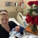 A woman carrying a newborn child