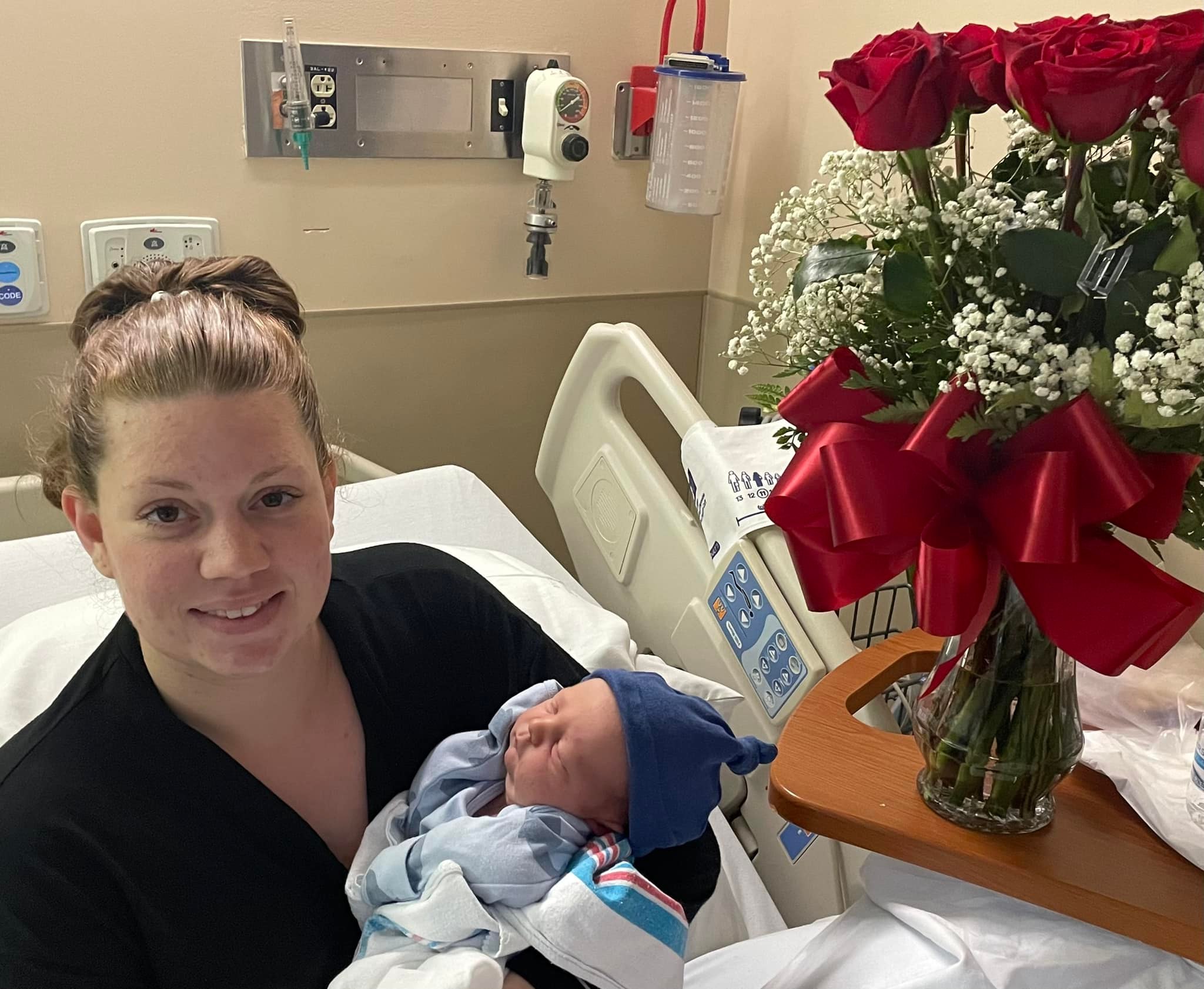 A woman carrying a newborn child