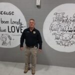 Sheriff Jody Greene with two of the new murals at the shelter. The murals are just some of the improvements that have been made at the shelter.