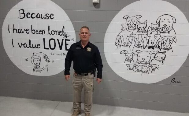 Sheriff Jody Greene with two of the new murals at the shelter. The murals are just some of the improvements that have been made at the shelter.
