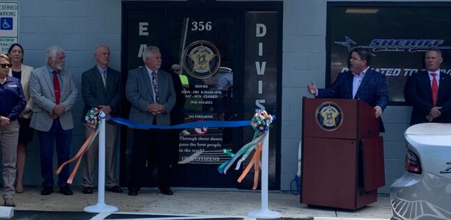 Rep. Brenden Jones, flanked by Sheriff Jody Green and county officials, speaks to the crowd Wednesday.
