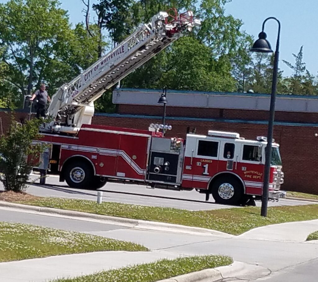 Whiteville Fire Department raised a large American flag over Columbus Street beside the Police Department as WPD officers stood at attention for the procession.