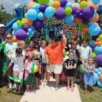 County Parks and Rec Director Julie Strickland cuts the ribbon officially opening the Trillium Play Area, with a little help from some of her closest friends.