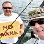 tate Parks staffers with one of the signs recently repaired at Lake Waccamaw.