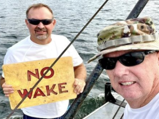 tate Parks staffers with one of the signs recently repaired at Lake Waccamaw.