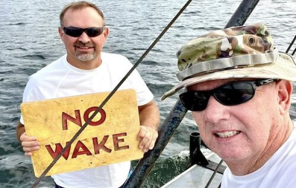 tate Parks staffers with one of the signs recently repaired at Lake Waccamaw.