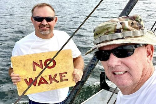 tate Parks staffers with one of the signs recently repaired at Lake Waccamaw.