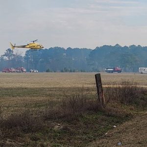A Forest Service helicopter lands in a field preparatory to making another water attack. (File photo)