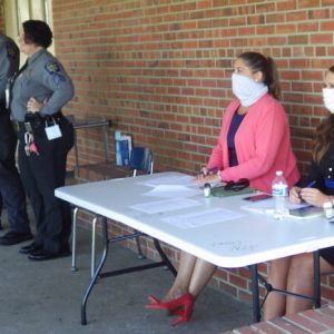 District Attorney's office staff members help direct patrons at the "Triage table" outside the Hallsboro courthouse. Bailiffs in this picture were taking a "mask break", since no visitors were nearby and court was in session. All court personnel and visitors are required to wear face coverings in the HMS courthouse.