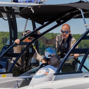 Officer Hannah Shively and officer Jake Thompson of the N.C. Wildlife Resources Commission Law Enforcement Division talk with boaters on Jordan Lake Tuesday, July 2, 2024. (WRC Photo)