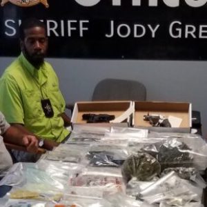 Sheriff Jody Greene, Chief of Detectives Jeremy Barber and Barrett Thompson of the Vice Narcotics unit with some of the drugs and other contraband seized during Friday's raids.
