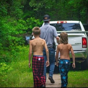 The two brothers are led out of the woods by searchers after spending the night in a tree stand. (CCSO photo)